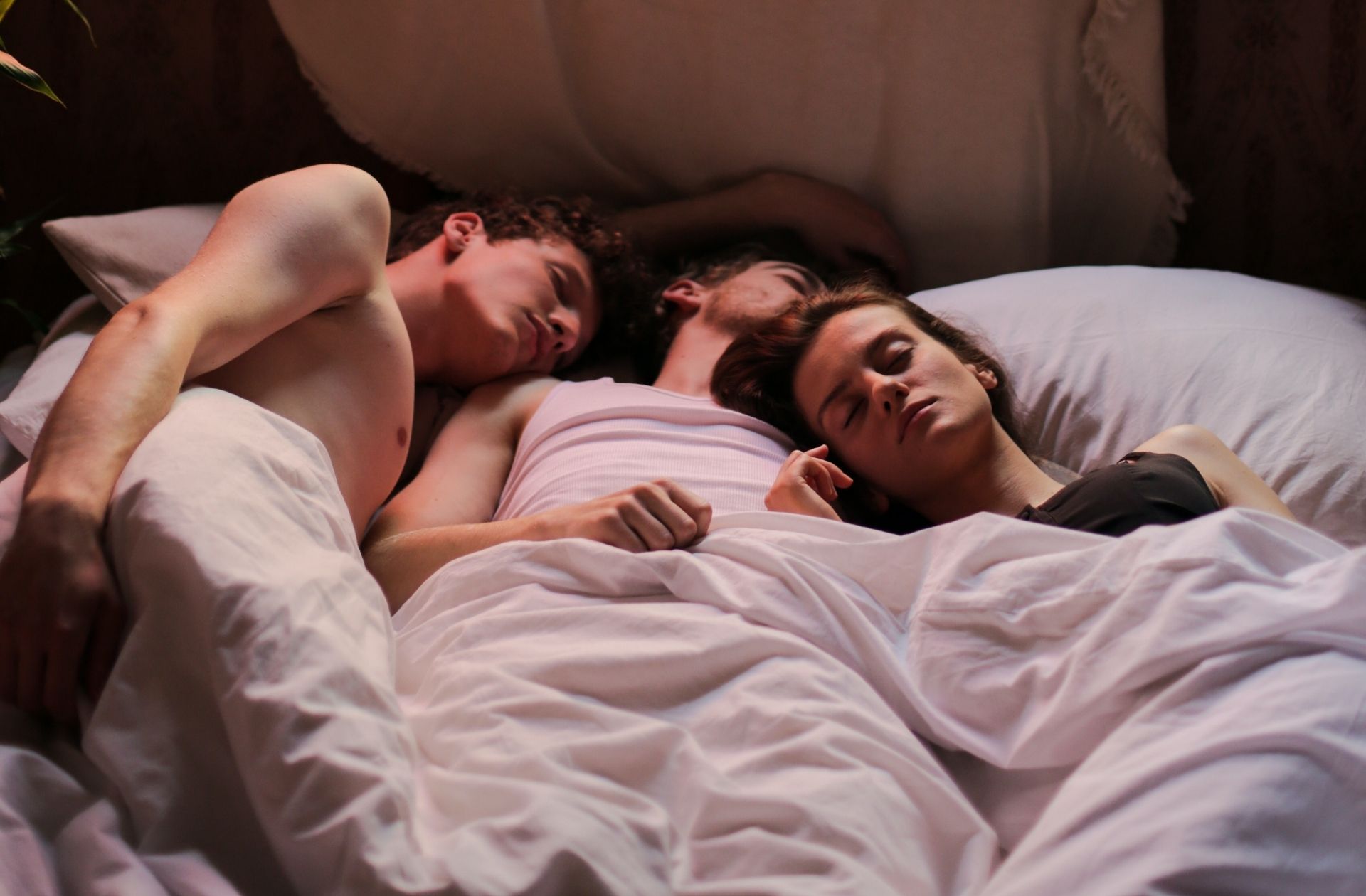 trois personnes dans un lit