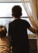 Deux enfants regardent par la fenêtre