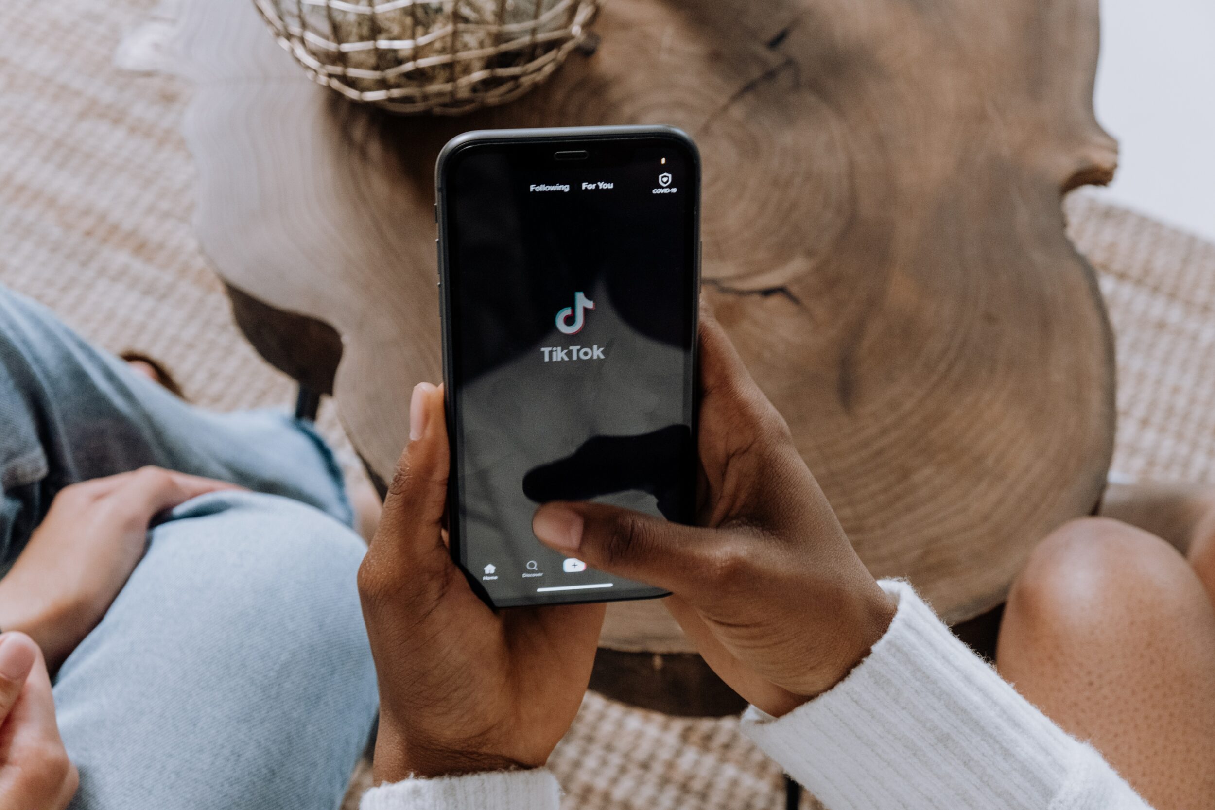 Personne tenant un smartphone dans la main et ouvrant l'application TikTok