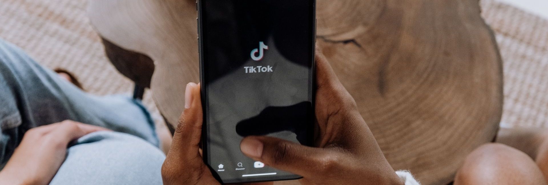 Personne ouvrant l'application TikTok sur son smartphone